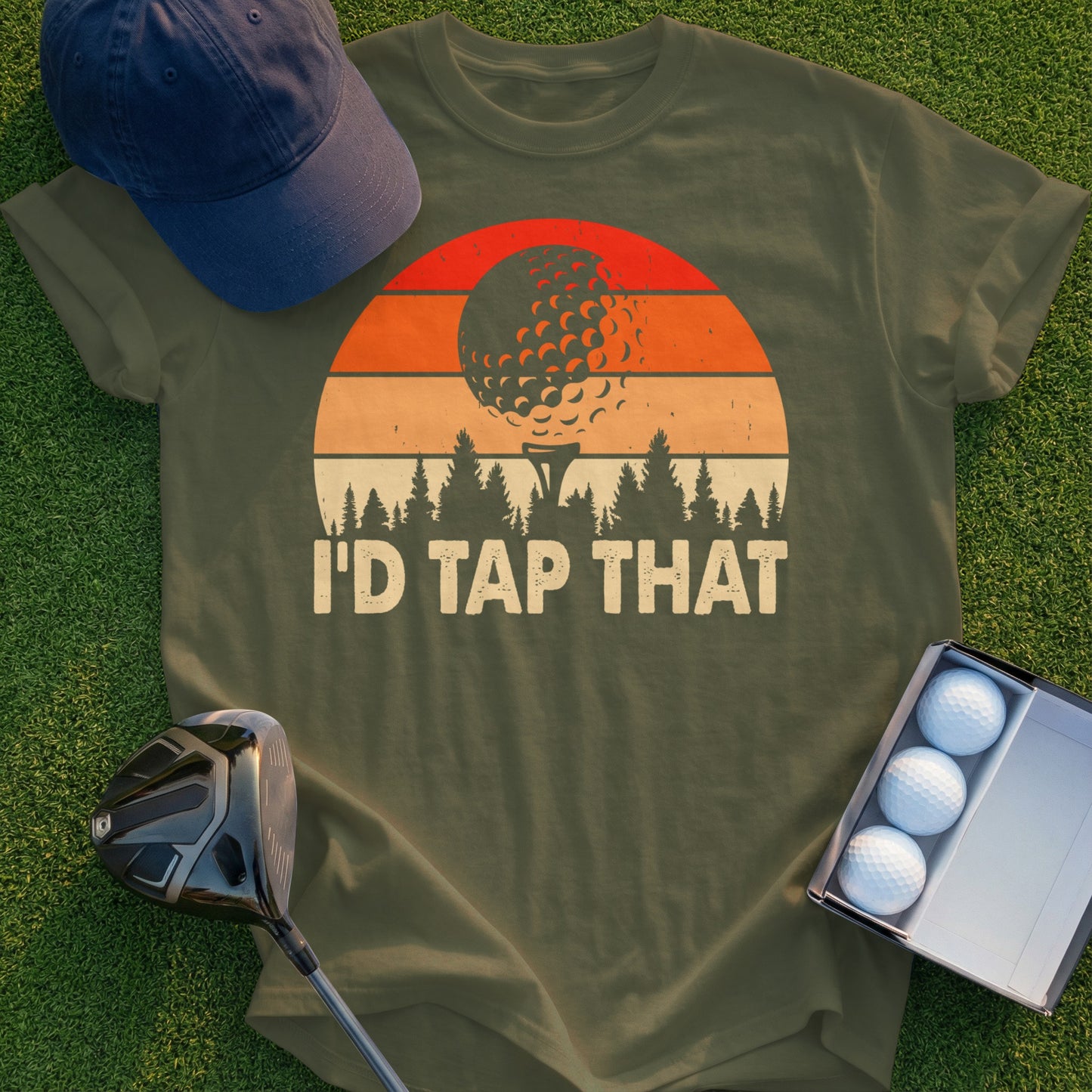 Olive green t-shirt with "I'd Tap That" and golf ball sunset graphic.