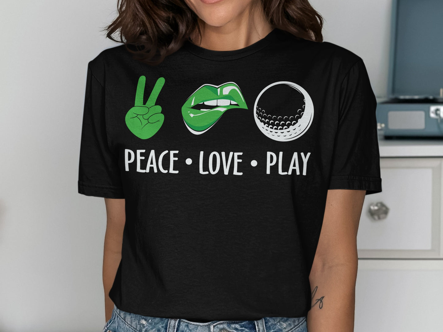 Black t-shirt with "PEACE LOVE PLAY" and peace sign, lips, and golf ball graphics.