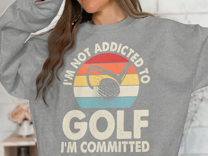 Gray sweatshirt with "I'M NOT ADDICTED TO GOLF I'M COMMITTED" and golf imagery.