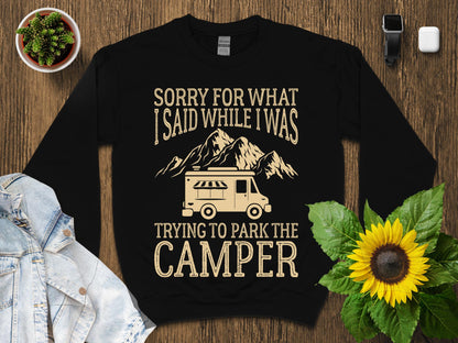 Black sweatshirt with "Sorry for what I said while trying to park the camper" text and graphics.