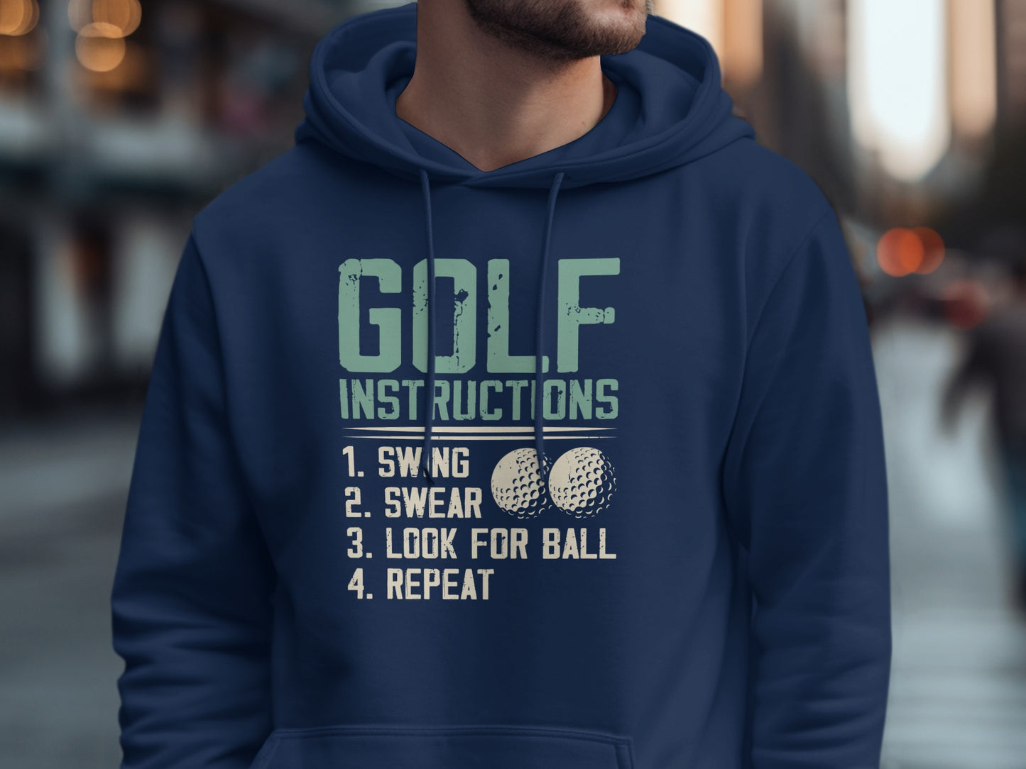 Navy blue hoodie with "GOLF INSTRUCTIONS SWING, SWEAR, LOOK FOR BALL, REPEAT" text and golf balls.