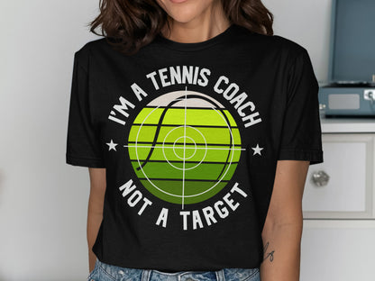 Black t-shirt with "I'M A TENNIS COACH NOT A TARGET" and tennis ball graphic.