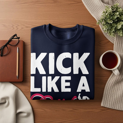 Navy sweatshirt with "KICK LIKE A GIRL" text, on a wooden table.