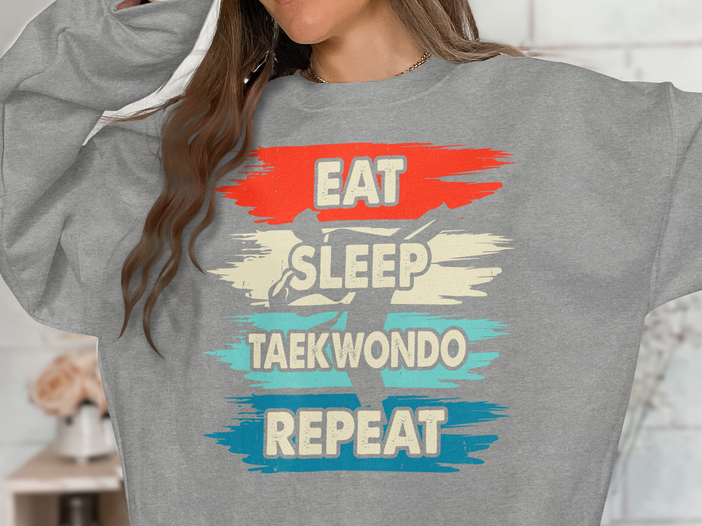 Gray sweatshirt with "Eat Sleep Taekwondo Repeat" text and silhouette.