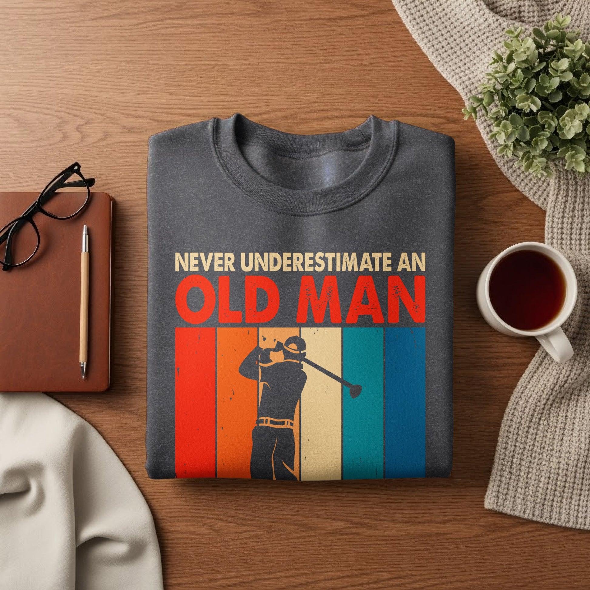 Dark gray sweatshirt with "NEVER UNDERESTIMATE AN OLD MAN" and golfer graphic.