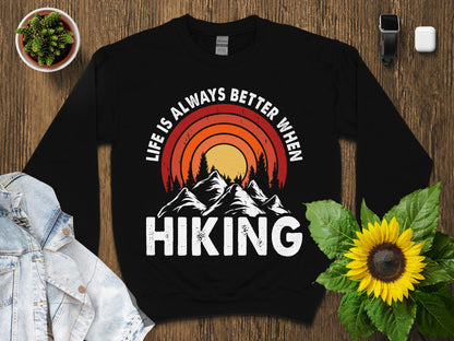 Black sweatshirt with "Life is Always Better When Hiking" and mountain sunset graphic.