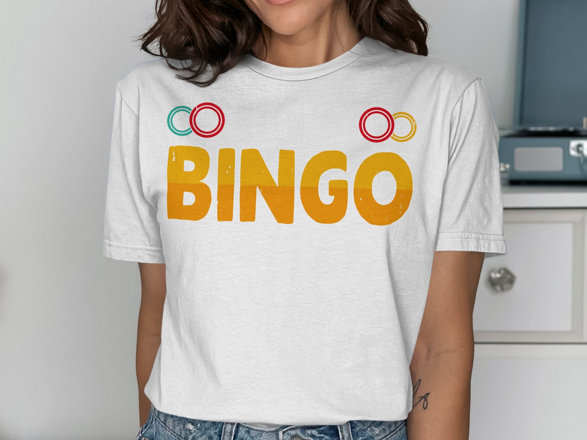 White t-shirt with "BINGO" in orange letters and red and yellow circles.