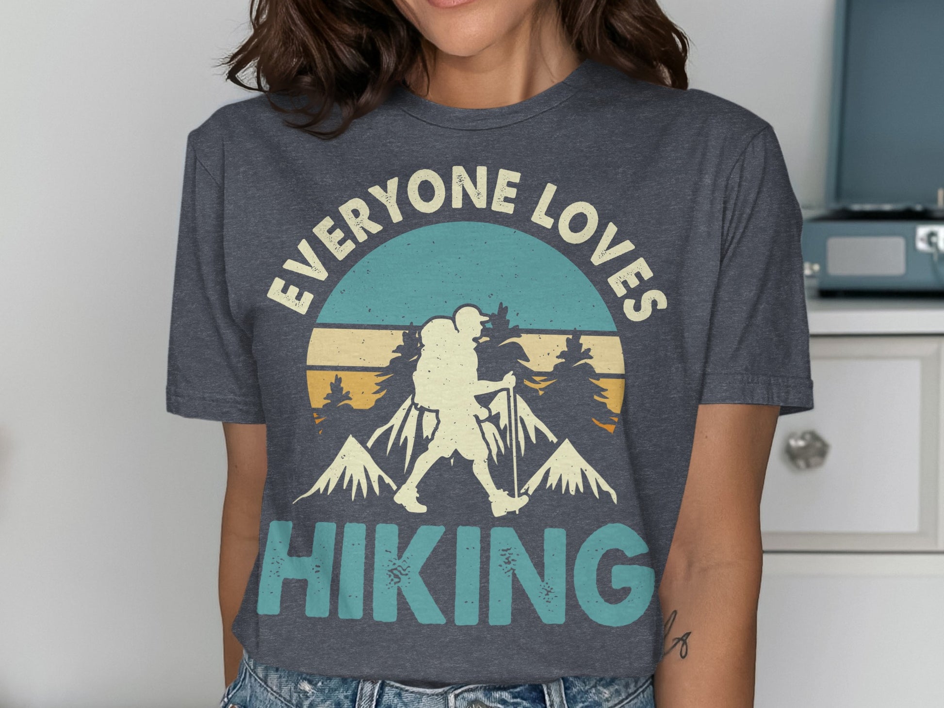 "EVERYONE LOVES HIKING" graphic tee with mountain and hiker illustration.