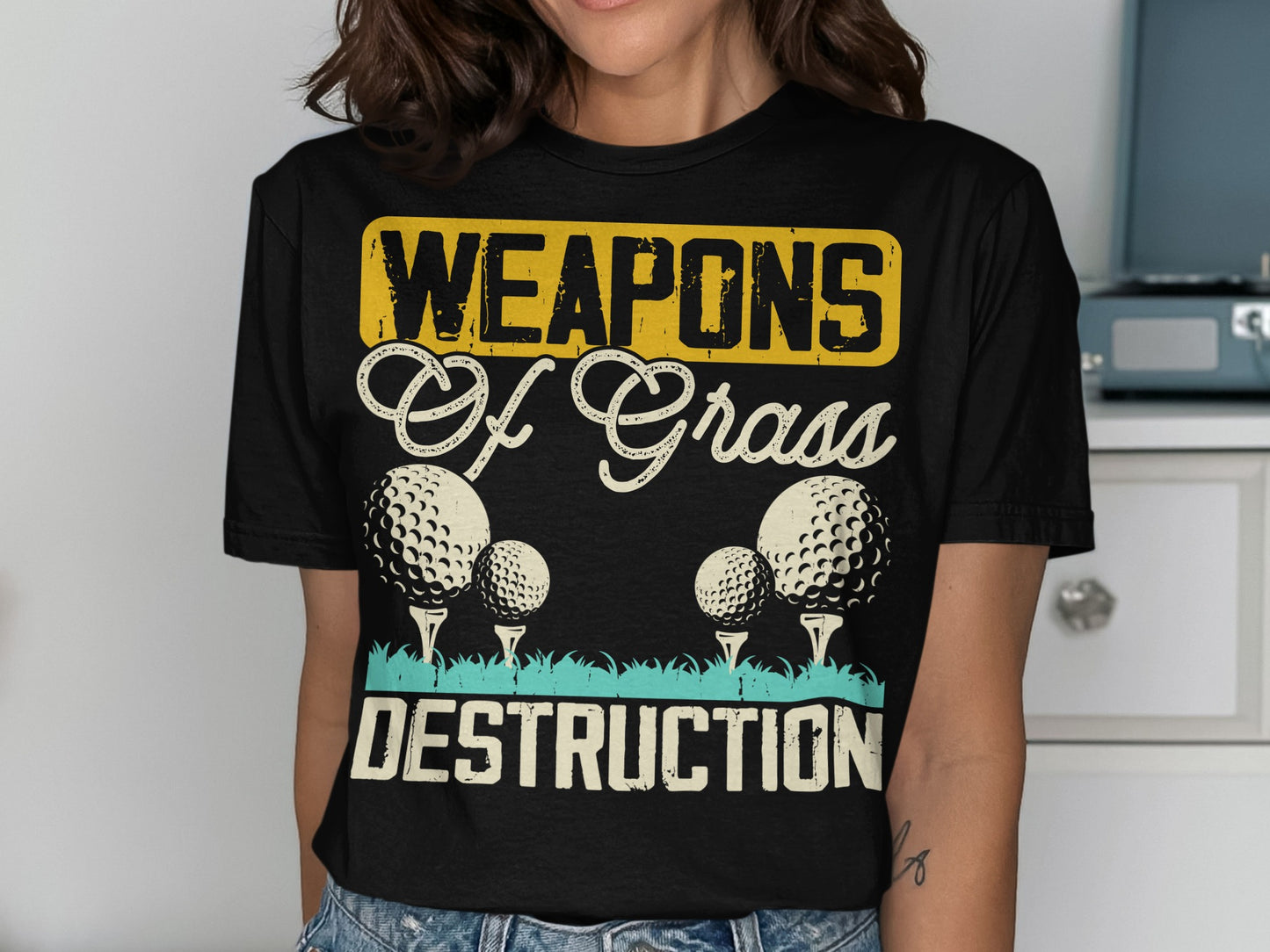 T-shirt with golf balls and "Weapons of Grass Destruction" text.