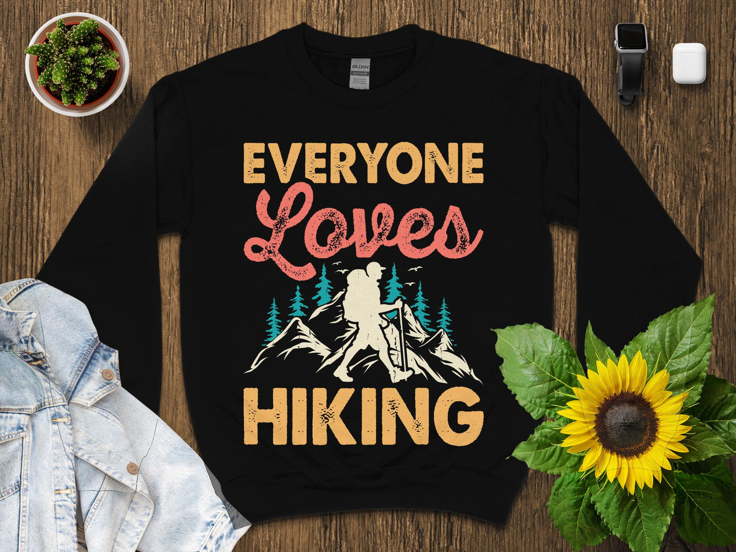 Black sweatshirt with "Everyone Loves Hiking" text and mountain graphic.