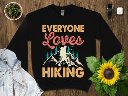 Black sweatshirt with "Everyone Loves Hiking" text and mountain graphic.