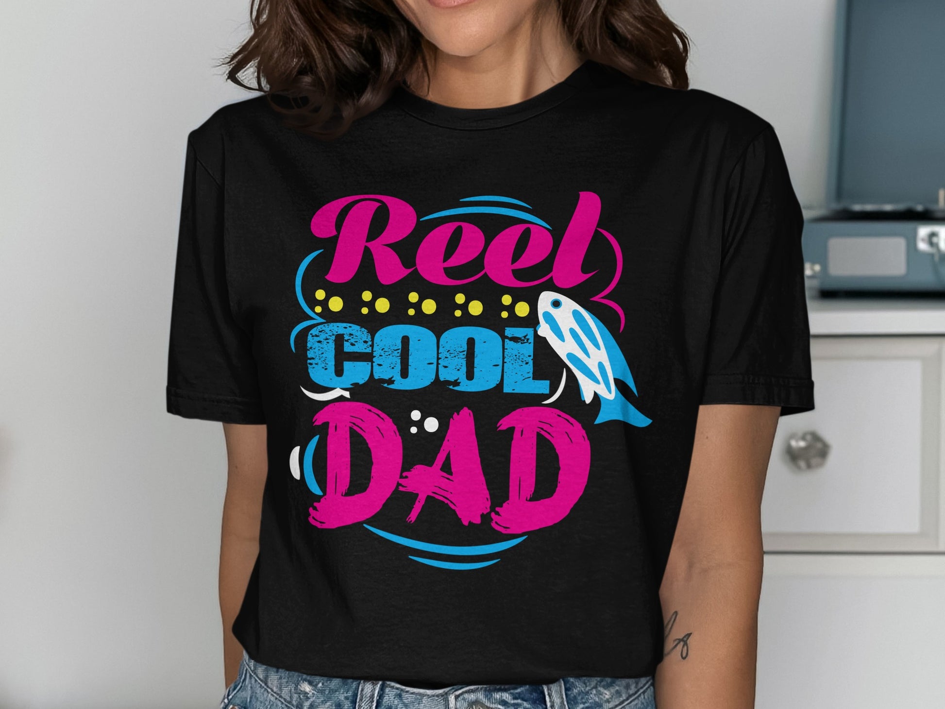 T-shirt with "Reel Cool Dad" text, fish graphic, and colorful dots.