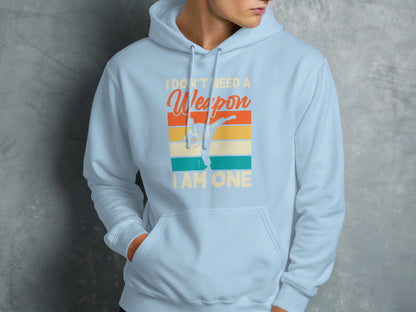 Light blue hoodie with "I Don't Need A Weapon I Am One" text and martial artist graphic.