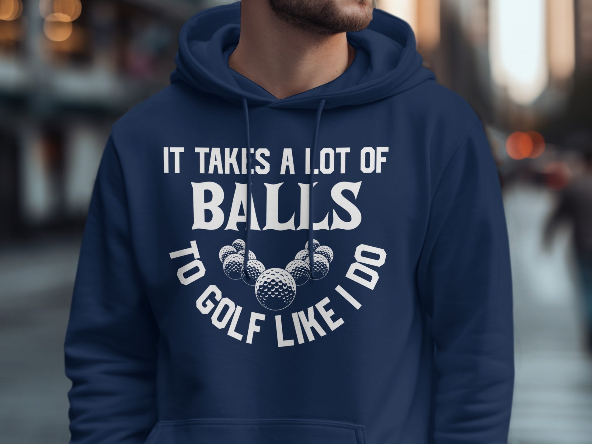 Navy hoodie with white text and golf balls graphic saying "It takes a lot of balls to golf like I do".