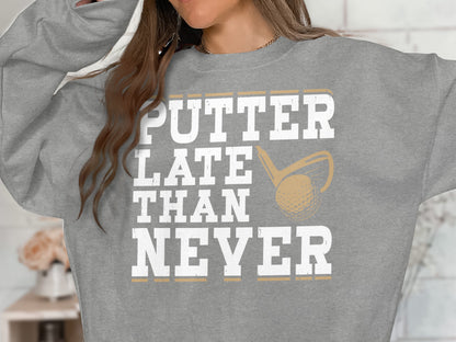 Grey sweatshirt with "PUTTER LATE THAN NEVER" text and golf club graphic.