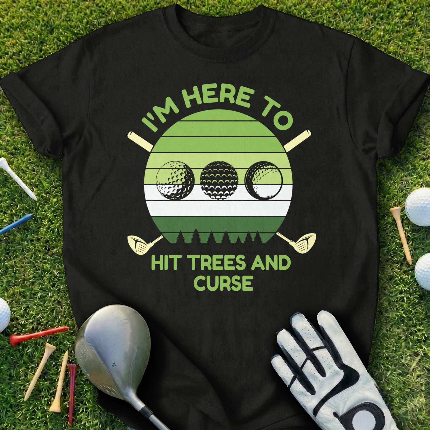 Black t-shirt with a graphic of three golf balls and "I'm here to hit trees and curse".