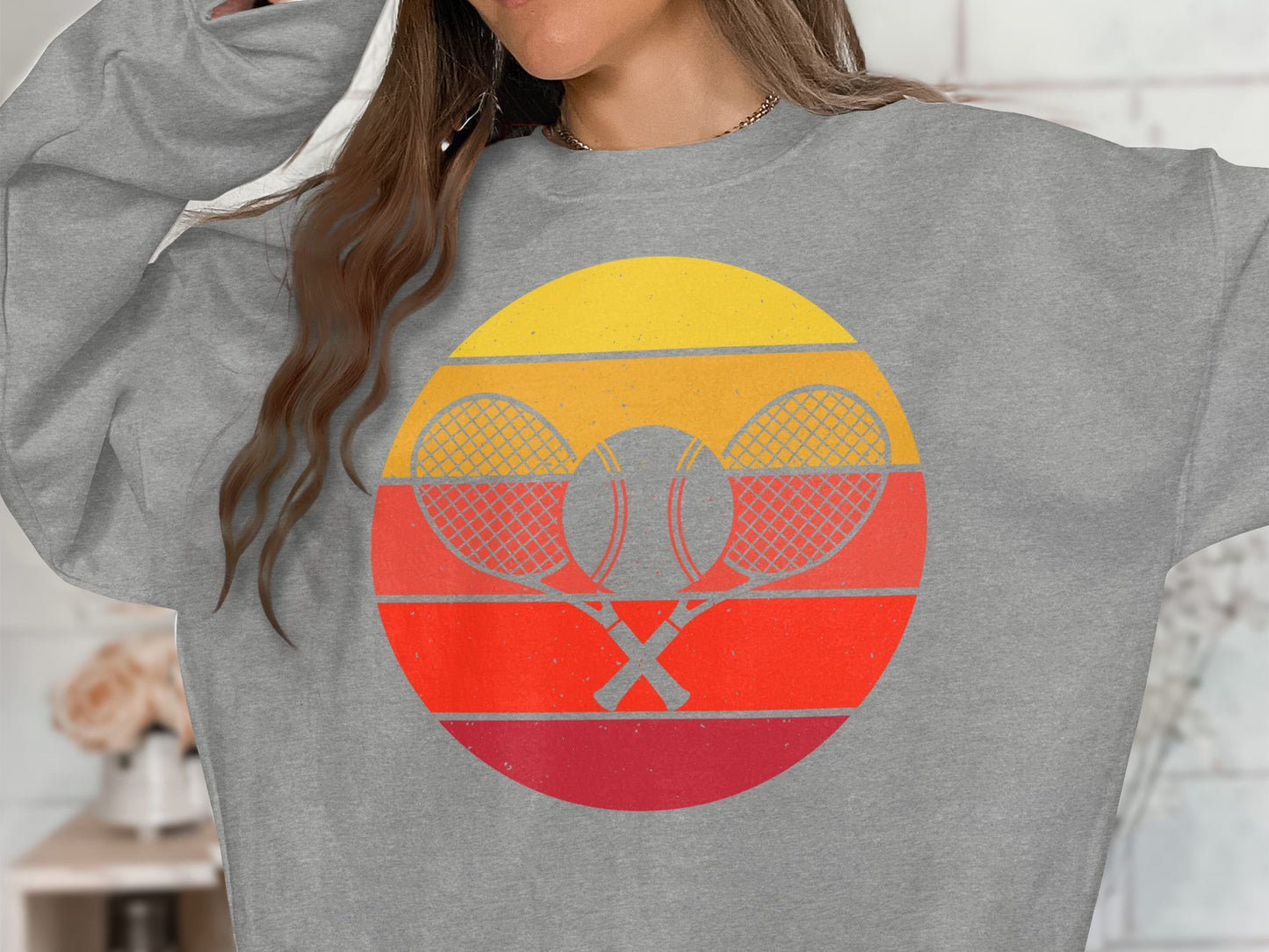 Gray sweatshirt with a circular retro tennis graphic featuring crossed rackets and ball.