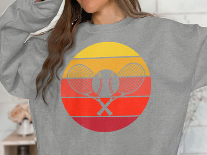 Gray sweatshirt with a circular retro tennis graphic featuring crossed rackets and ball.