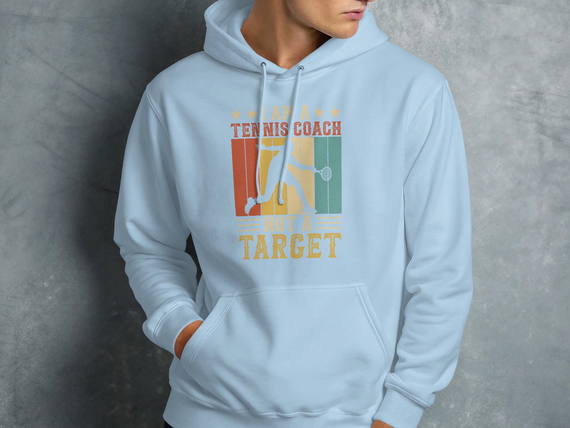 Light blue hoodie with "Tennis Coach, Not a Target" text and tennis graphic.