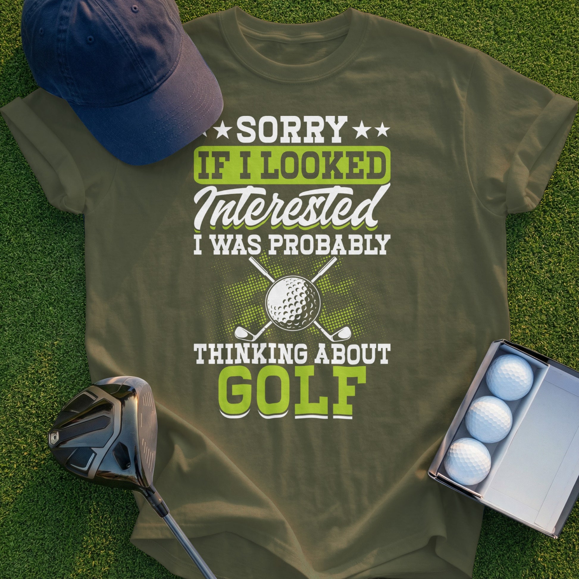 Olive green t-shirt with "Sorry if I looked interested, I was probably thinking about golf" text.