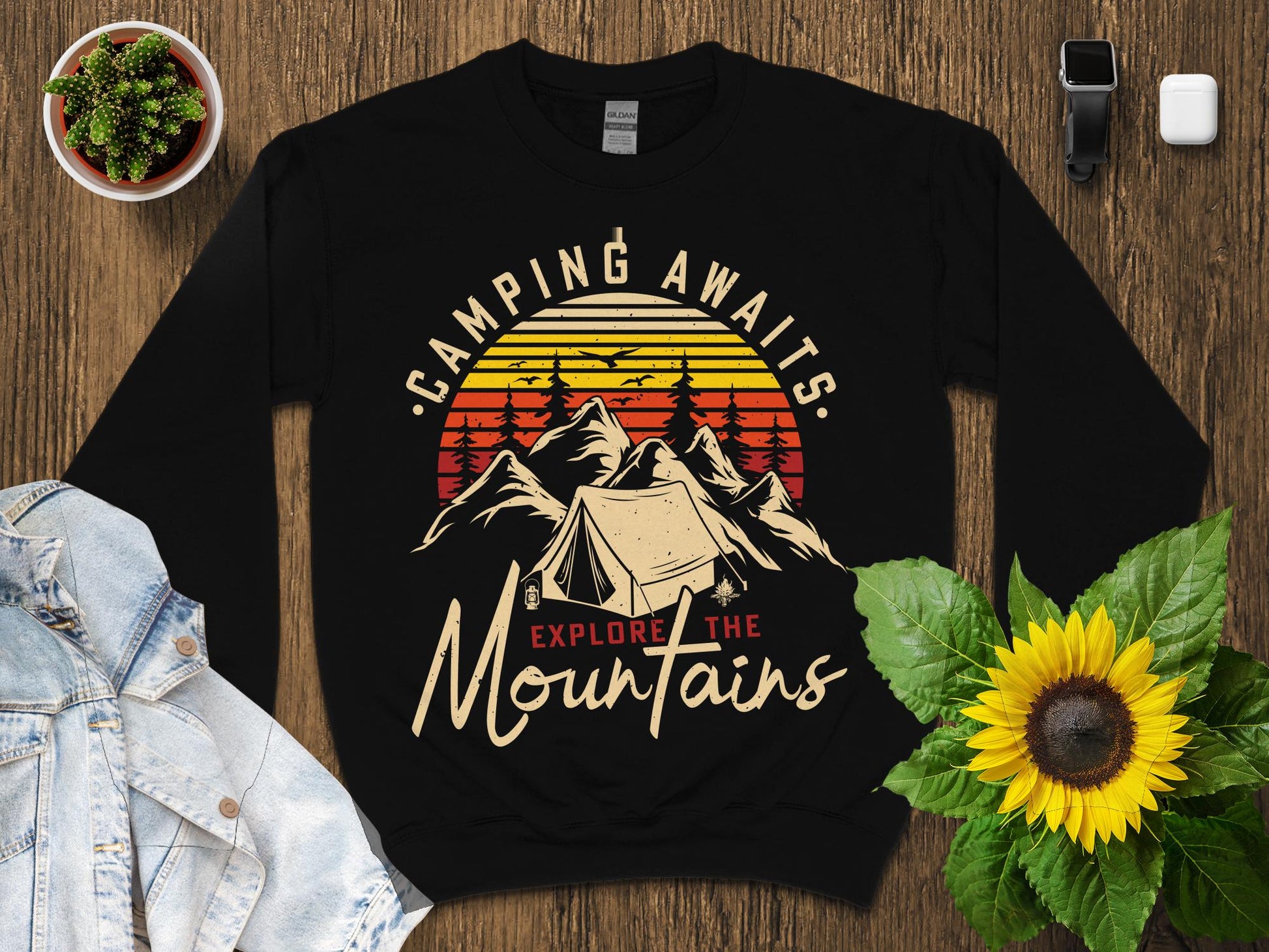 Black sweatshirt with "Camping Awaits Explore the Mountains" text and tent graphic.