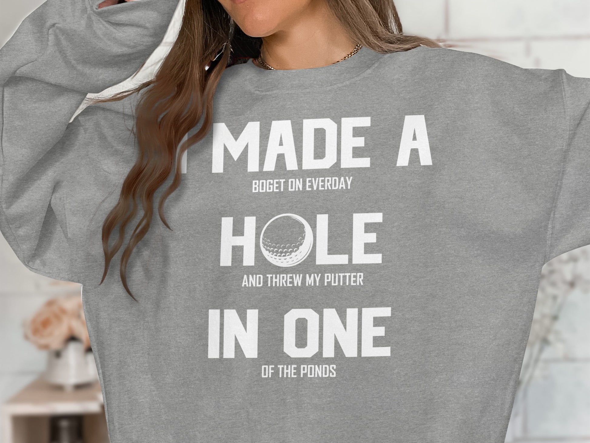 Gray sweatshirt with white text reading "I made a boget on everyday hole and threw my putter in one of the ponds."