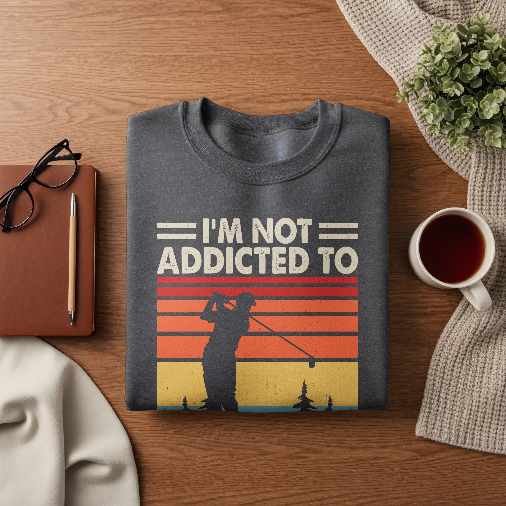 Dark grey sweatshirt with "I'M NOT ADDICTED TO" and a golfer at sunset graphic.