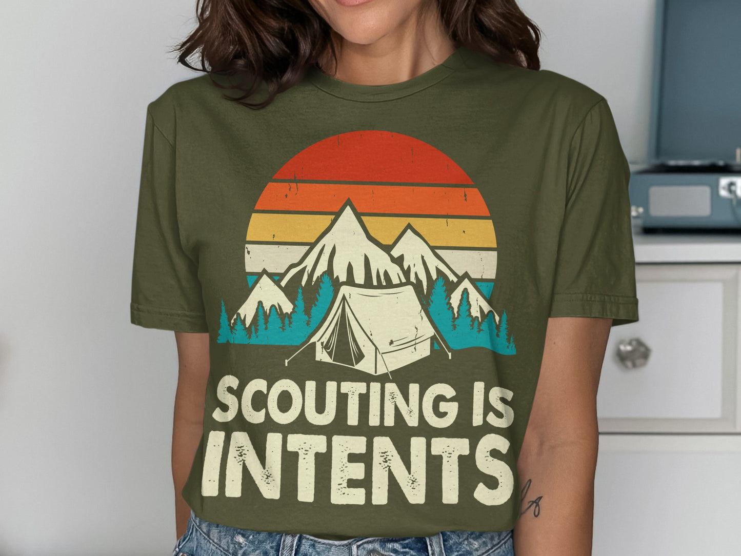 Olive green t-shirt with mountains, tent, and "Scouting is Intents" text.