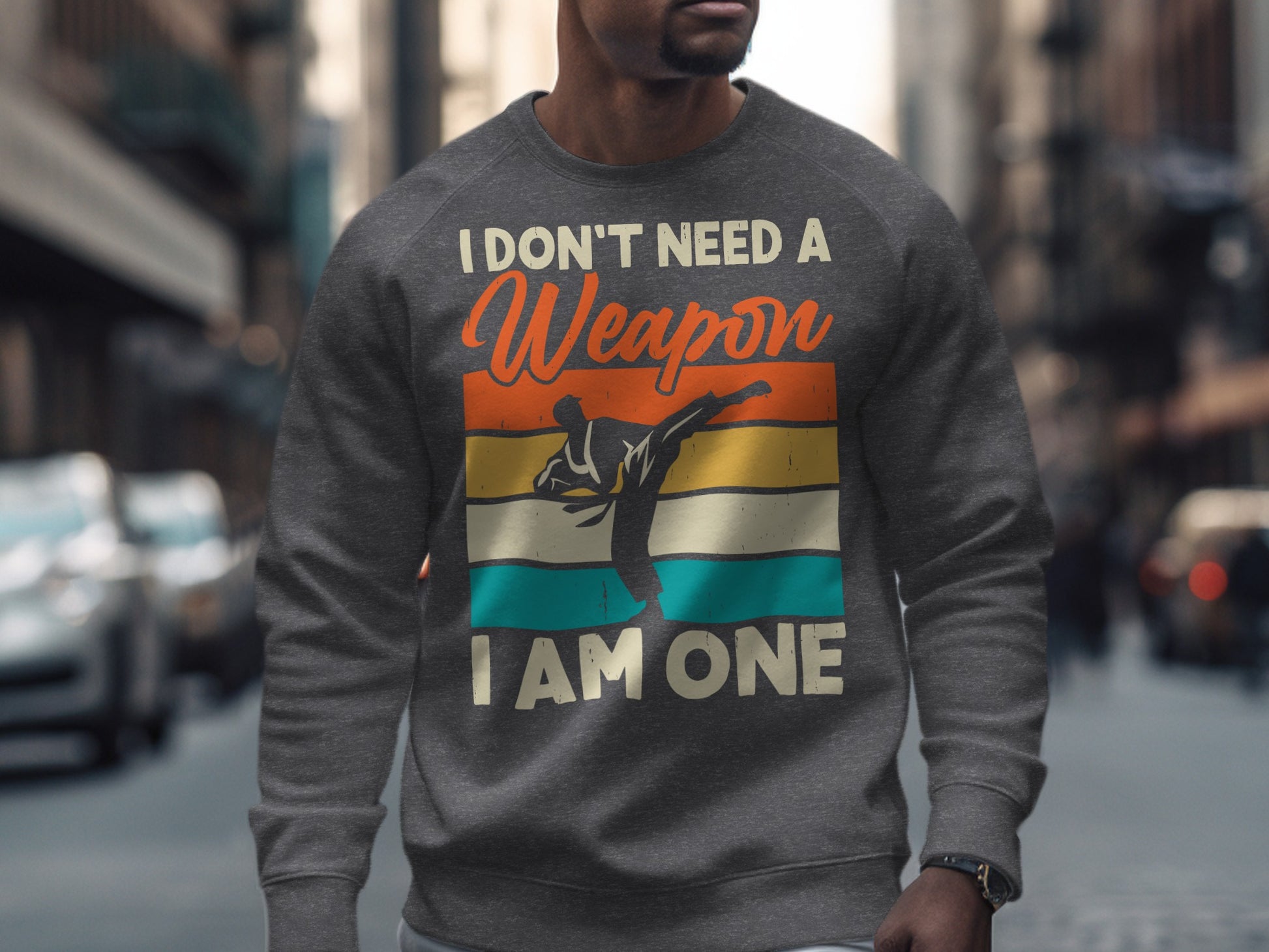 Gray sweatshirt with martial artist silhouette and text: "I DON'T NEED A WEAPON, I AM ONE."