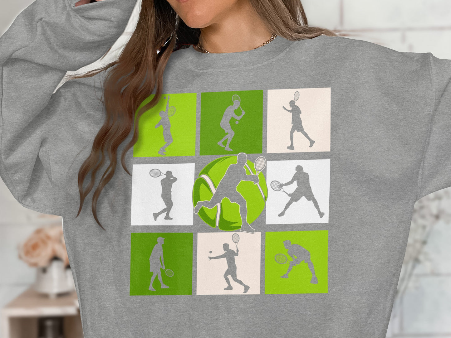 Tennis player silhouettes in nine green and white squares on a gray sweatshirt.