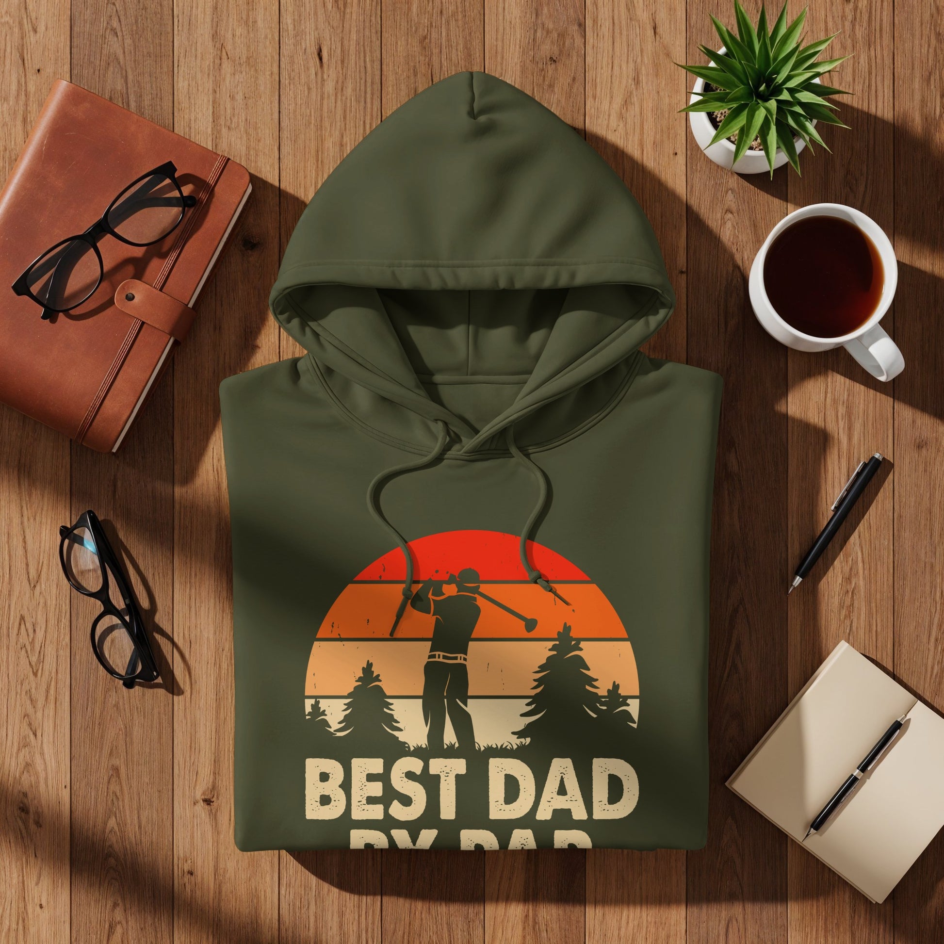 Olive green hoodie with golfer and sunset graphic, "BEST DAD" text.