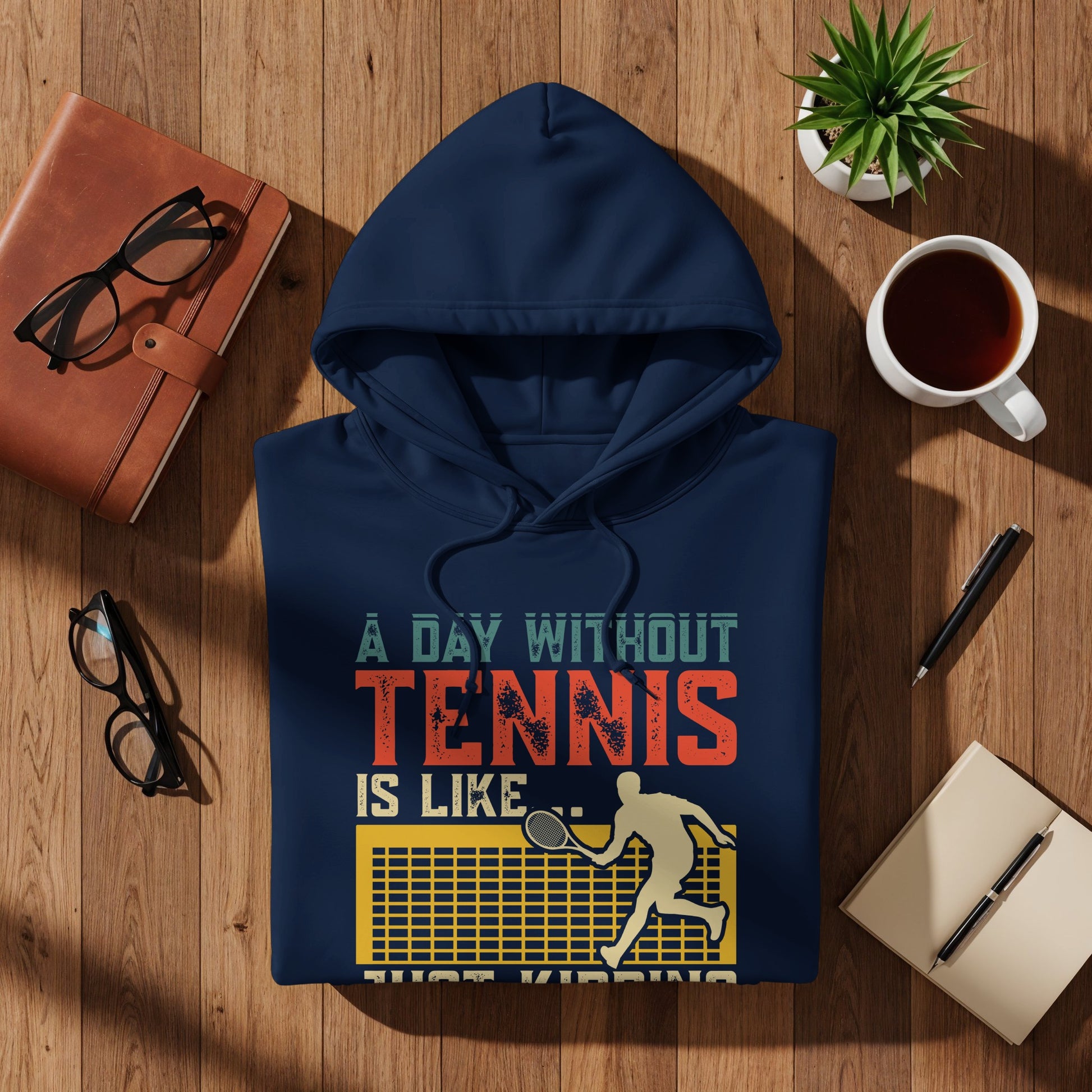 Navy hoodie with "A Day Without Tennis is Like... Just Kidding" text and tennis player graphic.