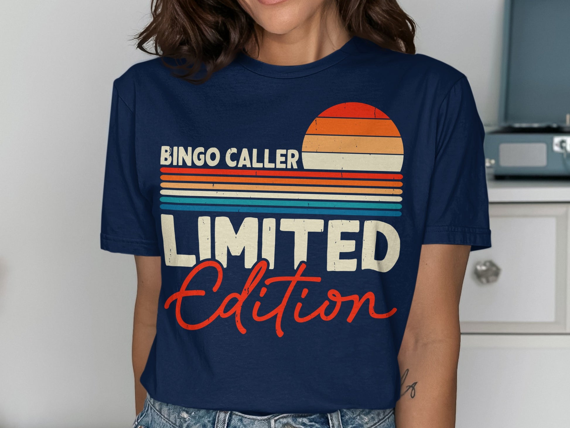 Navy t-shirt with "Bingo Caller LIMITED Edition" text and a sunset graphic.