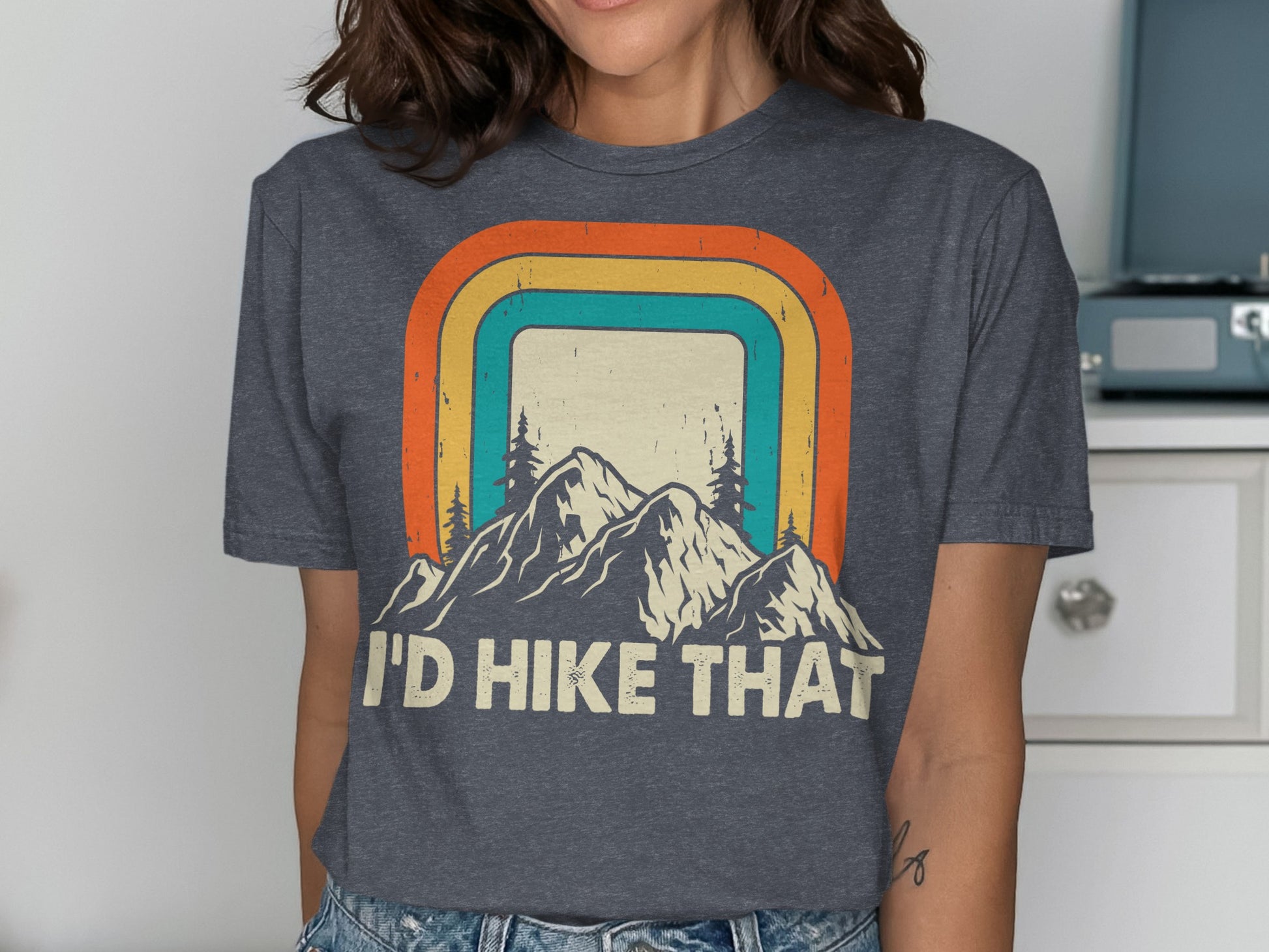 Dark gray t-shirt with "I'D HIKE THAT" text and mountain sunset graphic.