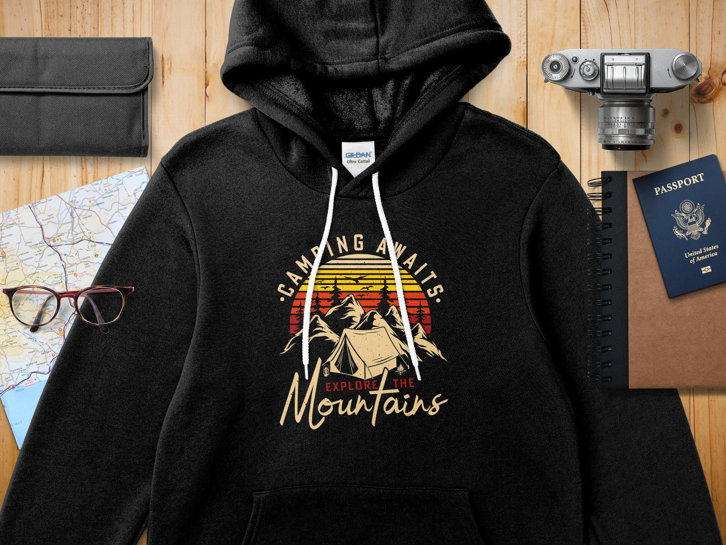 Black hoodie with "CAMPING AWAITS EXPLORE THE Mountains" text and mountain graphic.