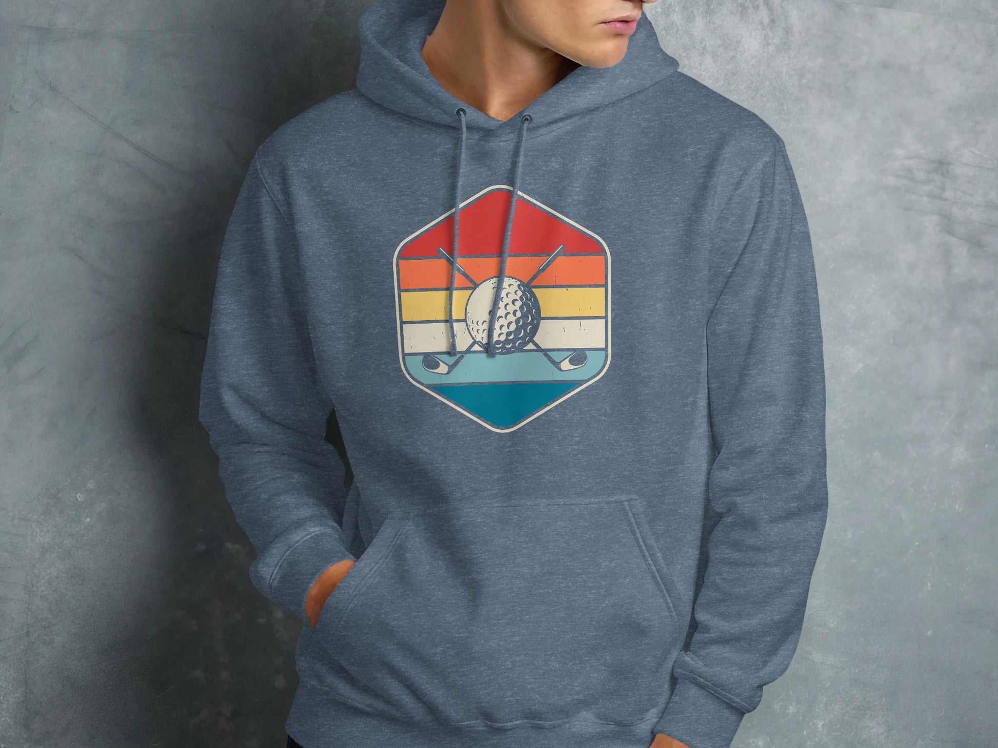 Hexagonal logo with golf clubs, ball, and sunset on a blue heather hoodie.