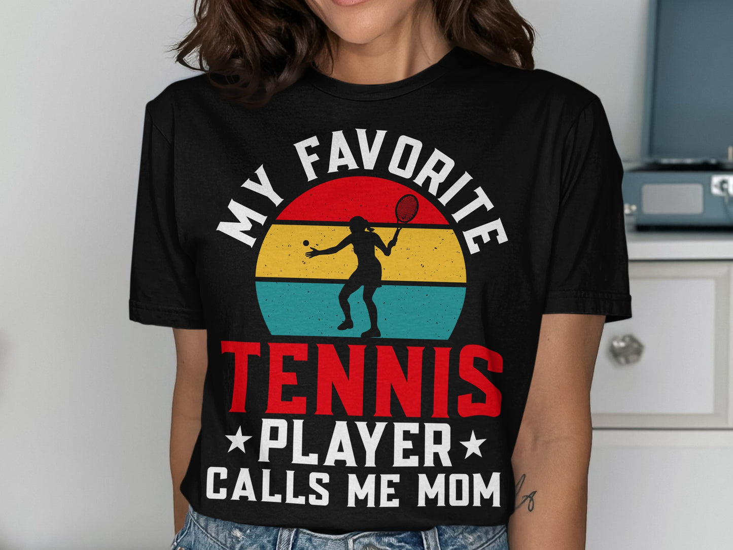 Black t-shirt with "My Favorite Tennis Player Calls Me Mom" text and tennis graphic.