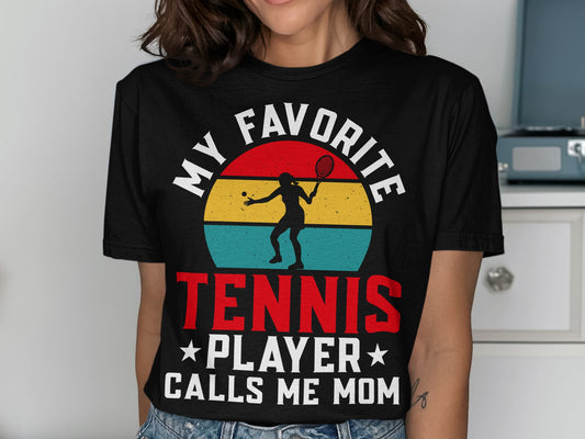 Black t-shirt with "My Favorite Tennis Player Calls Me Mom" text and tennis graphic.