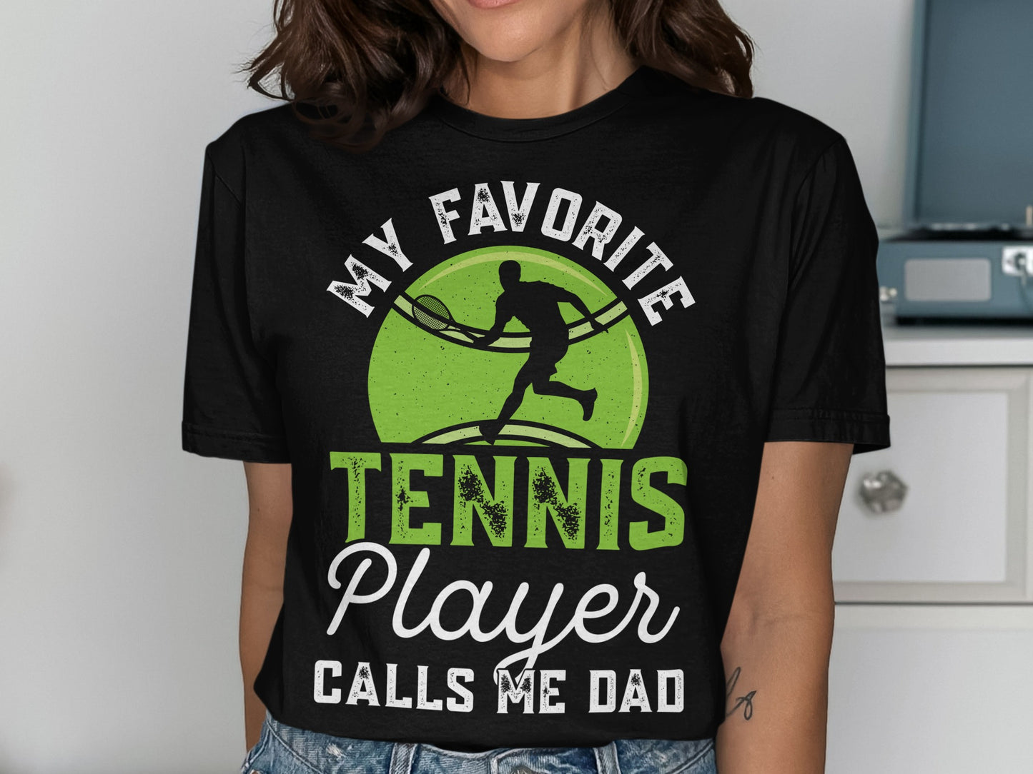 Black t-shirt with "MY FAVORITE TENNIS PLAYER CALLS ME DAD" text and tennis graphic.