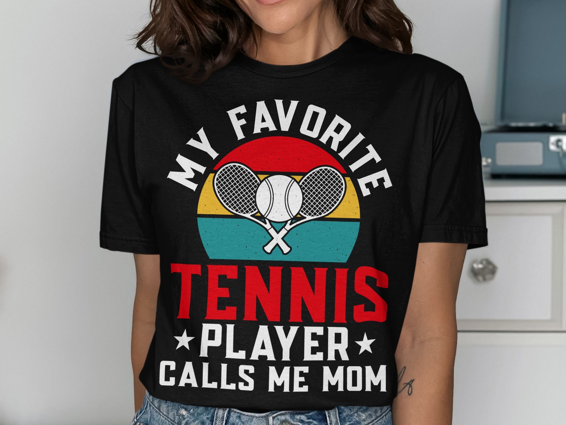 Black t-shirt with "My Favorite Tennis Player Calls Me Mom" and crossed tennis rackets.