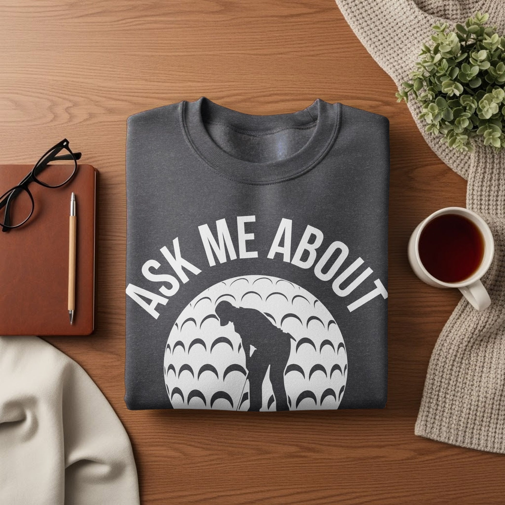 Dark grey crewneck sweatshirt with "Ask Me About Golf" text and golf ball graphic.
