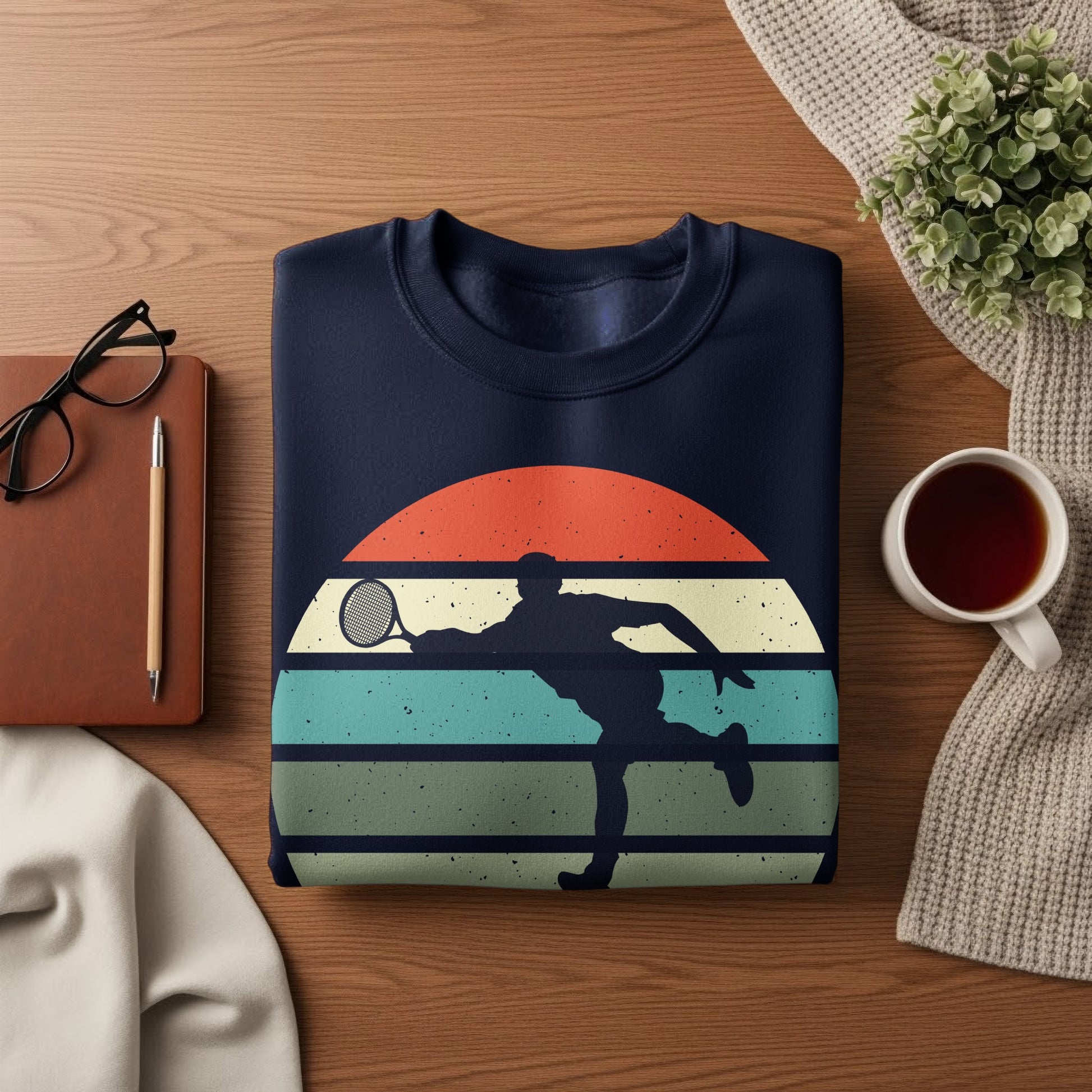 Navy sweatshirt with retro tennis player silhouette and striped sunset graphic.
