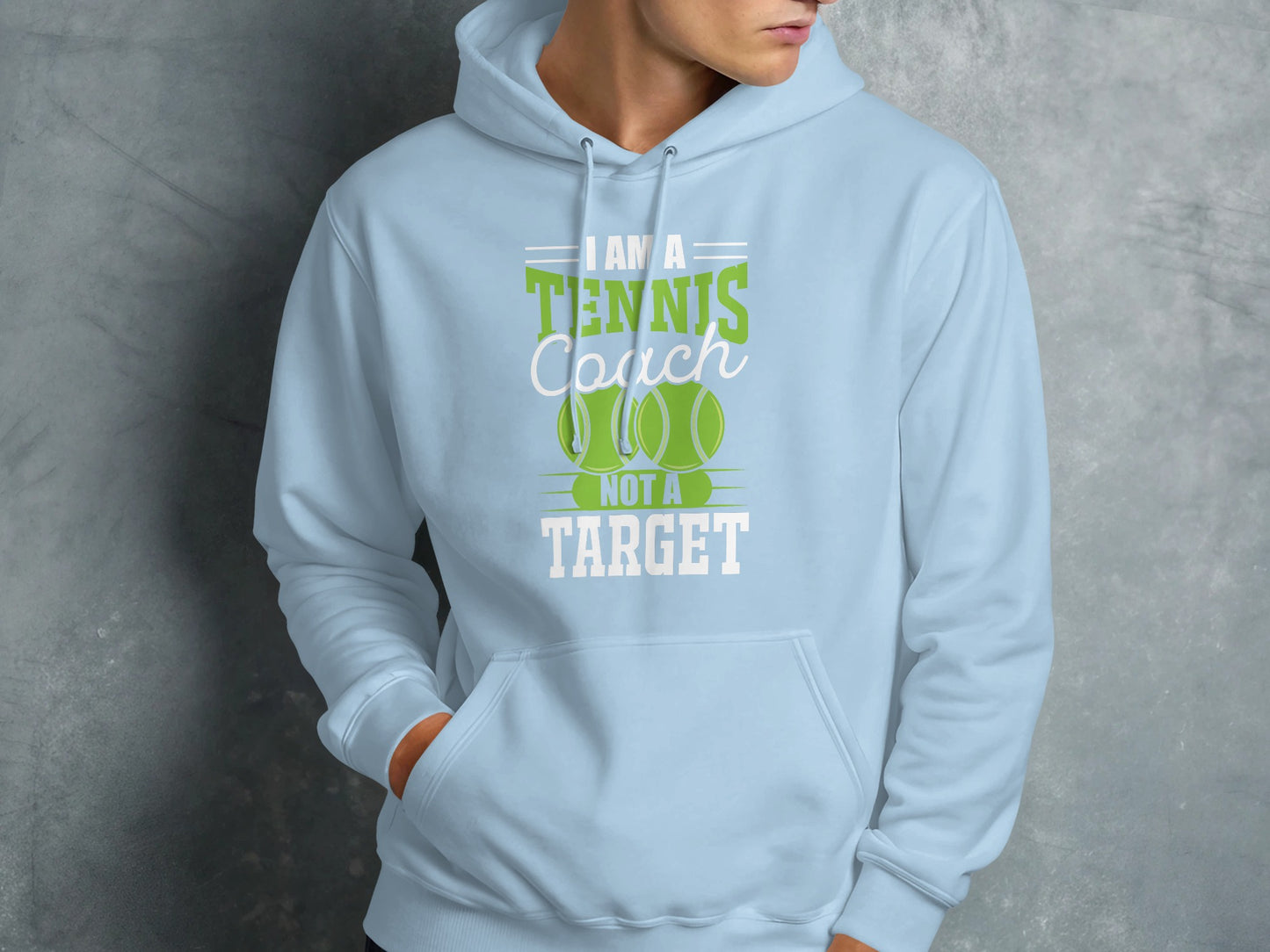 Light blue hoodie with text "I am a tennis coach not a target" and tennis balls.