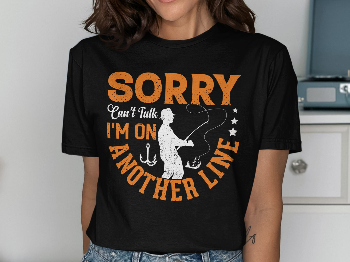 Black t-shirt with "SORRY CAN'T TALK I'M ON ANOTHER LINE" and fishing graphics.