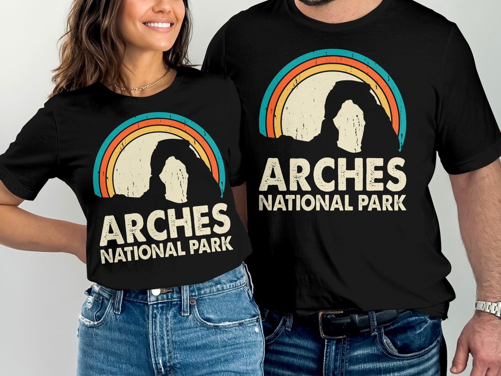 Arches National Park graphic on black t-shirts worn by a man and woman.