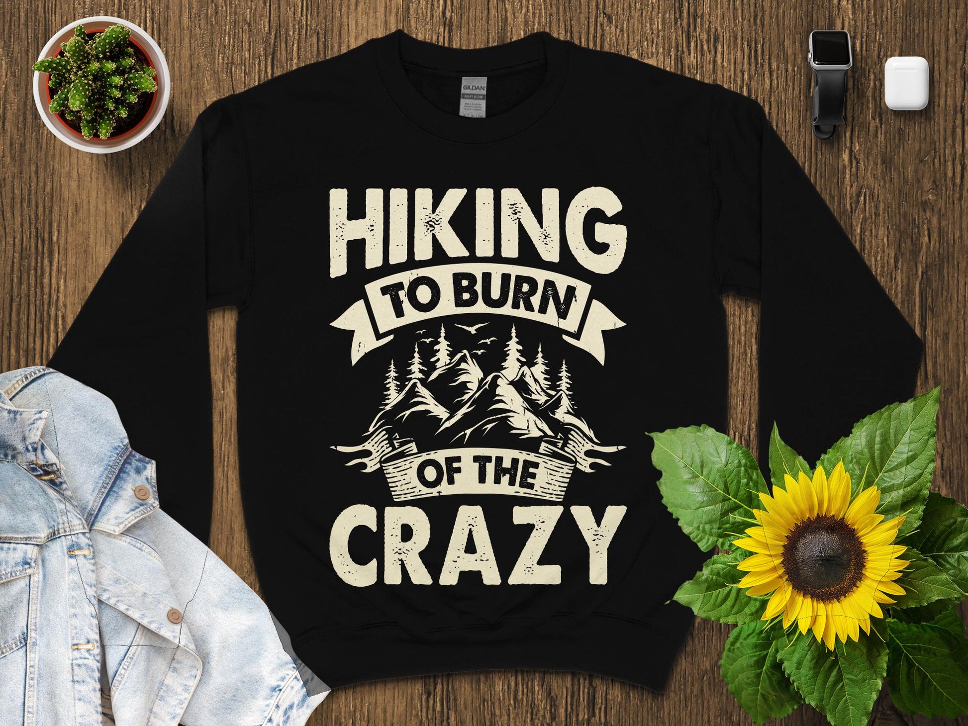 Black sweatshirt with "Hiking to burn of the crazy" text and mountain graphic.