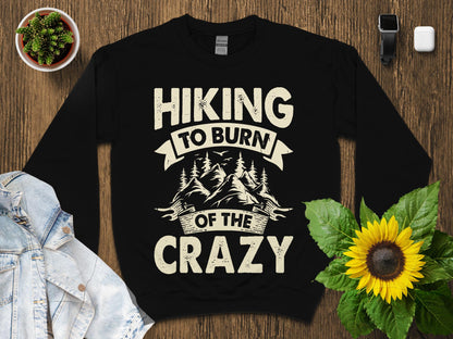 Black sweatshirt with "Hiking to burn of the crazy" text and mountain graphic.