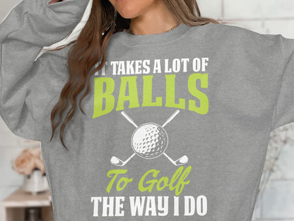 Grey sweatshirt with text "It takes a lot of balls to golf the way I do".