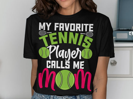 Black t-shirt with "My Favorite Tennis Player Calls Me Mom" text and tennis imagery.
