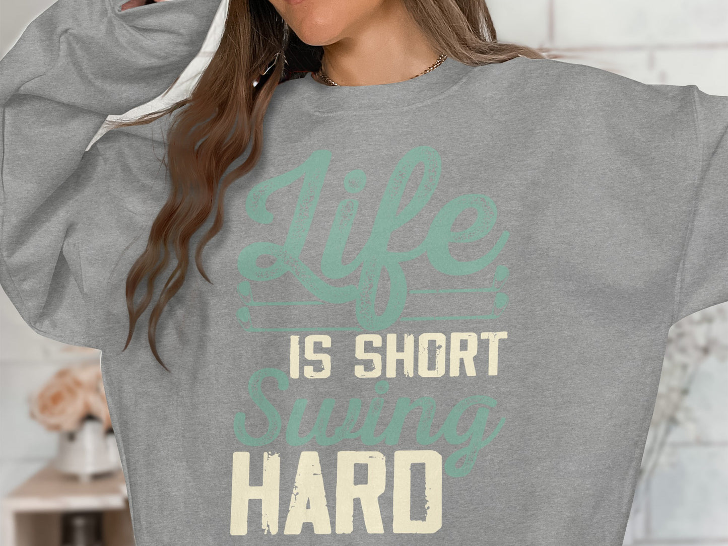 Grey sweatshirt with "Life is Short Swing Hard" text.